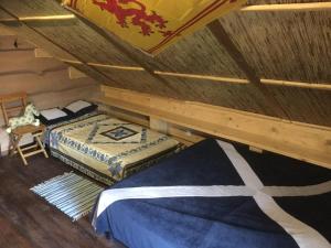 a attic room with two beds and a chair at Salamandra Village in Kozevo