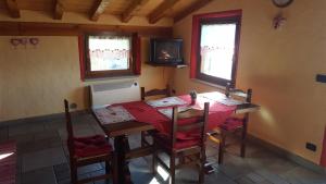 a dining room with a table with chairs and a television at Maien Piolet Milieu in Doues