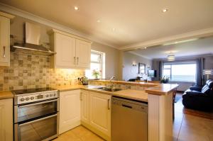 a kitchen with a sink and a stove top oven at Seabreeze Apartment in Renvyle