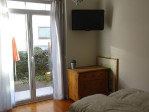 ein Schlafzimmer mit einem Bett, einer Kommode und einem Fenster in der Unterkunft City Appartement in Baden-Baden
