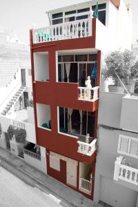 a red and white building with a balcony at Casa Alcala in Alcalá