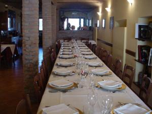 a long table with plates and wine glasses on it at Agriturismo Le Gazze in Camposanto