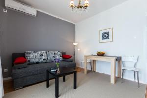 salon z kanapą i stołem w obiekcie Apartments Tomislav Primorska w Novalji