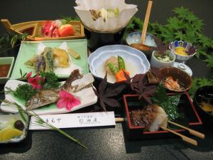 una mesa cubierta con platos de comida y palillos en Nitaya en Minakami