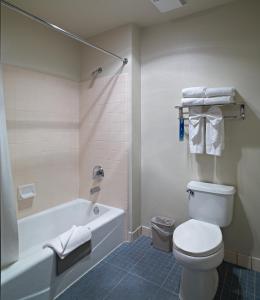 a bathroom with a tub and a toilet and a sink at Sequoia Inn in Hanford
