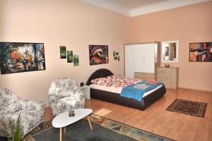 een slaapkamer met een bed en twee stoelen bij Tesla Apartment in Sarajevo