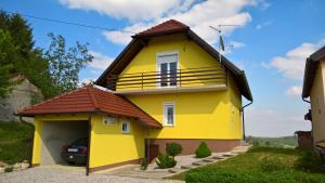 uma casa amarela com garagem em Holiday Home Fijolica em Štrigova