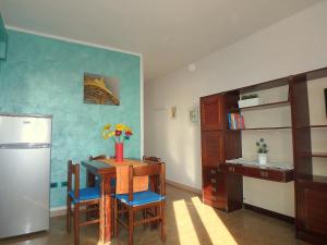 een keuken met een tafel met stoelen en een koelkast bij Esperia 23 in Lido di Pomposa