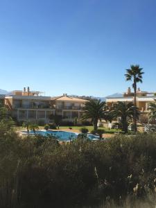 a resort with a swimming pool and palm trees at Oliva Nova Casas del Mar in Oliva