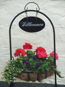 a flower pot hanging on a wall with flowers at Ferienhaus Zunftstuben in Norderney