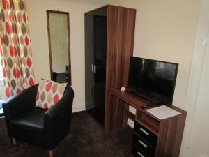 a living room with a tv and a chair and a televisionictericter at Adelphi Villa in Oban