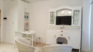 sala de estar blanca con TV y escritorio en Loft Almagro en Buenos Aires