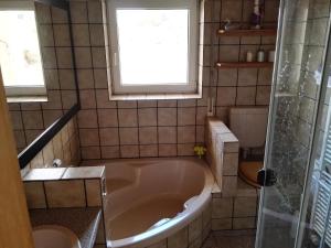 ein Bad mit einer großen Badewanne und einem Fenster in der Unterkunft Ferienwohnungen mit Weitblick in Bergneustadt + 37 Fotos