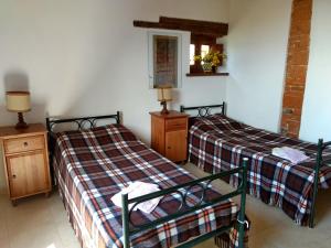 a bedroom with two beds and a mirror at Podere Pancoli in Massa Marittima