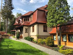 a house with a red roof and a yard at Villa Filmowiec in Polanica-Zdrój