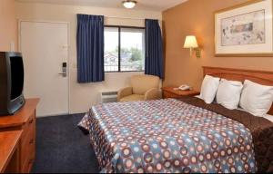 ein Hotelzimmer mit einem Bett und einem TV in der Unterkunft Americas Best Value Inn - Carson City in Carson City