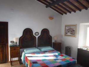 sypialnia z łóżkiem z kolorową kołdrą w obiekcie Rustico w mieście Bagnoregio