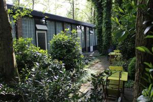 einen Garten mit Bänken und Bäumen und ein Gebäude in der Unterkunft Motel Paradiso in Bad Neuschanz