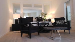 a living room with black chairs and a table at Relais Corte Degli Aragonesi in Ischia