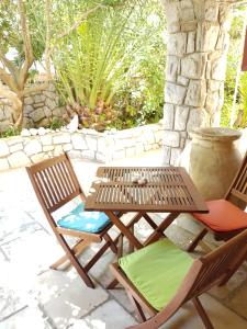 a patio with two chairs and a wooden table at Apartman Gabrijela in Mali Lošinj