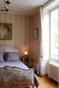 Schlafzimmer mit einem Bett und einem Fenster in der Unterkunft Chateau de Breuil en Beaujolais in Salles-Arbuissonnas