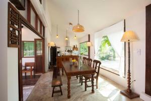 a dining room with a wooden table and chairs at Foresta Villa in Hang Dong