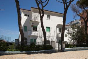 un edificio blanco con árboles delante de él en Villa San Francesco, en Misano Adriatico