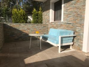 a blue couch and a table on a patio at Vergos Hotel in Vourvourou