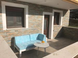 a blue couch on a patio with a table at Vergos Hotel in Vourvourou