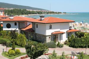 une grande maison blanche avec un toit orange dans l'établissement Helena VIP Villas and Suites - Half Board, à Sunny Beach