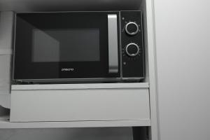 a microwave oven sitting on top of a white cabinet at Jägerhof Apartments in Wiesbaden
