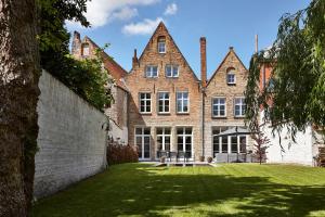 a large brick building with a lawn in front of it at La Maison de Nathalie in Bruges