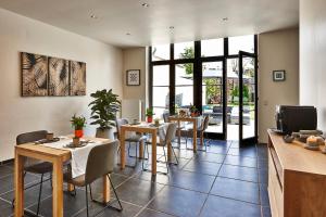 a dining room with tables and chairs and a tv at La Maison de Nathalie in Bruges