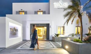 a woman walking in front of a building at De Sol Hotel & Spa in Fira