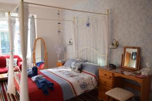a bedroom with a bed and a dresser and a mirror at The Lyndsay Guest House in Skegness