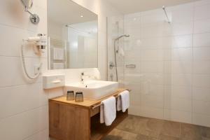 biała łazienka z umywalką i prysznicem w obiekcie Hotel Zontaja Superior w mieście Galtür