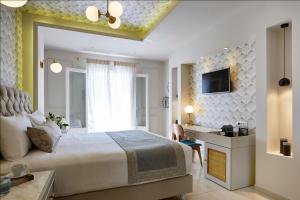 a hotel room with a bed and a television at De Sol Hotel & Spa in Fira