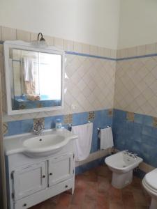 een blauwe en witte badkamer met een wastafel en een toilet bij la terrazza in Palaia