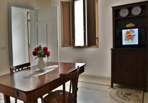 a dining room with a table and a vase of flowers at Casa Mazzara in Buseto Palizzolo