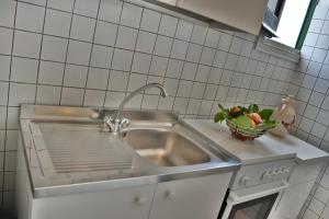 a kitchen with a sink and a bowl of fruit at Casa Mazzara in Buseto Palizzolo