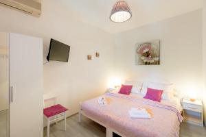 a small bedroom with a bed and a tv at Apartments Afrodita in Dubrovnik