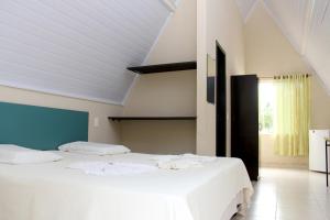 sypialnia z 2 łóżkami z białą pościelą w obiekcie Pousada do Lago Ltda w mieście Conceição do Mato Dentro