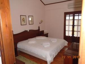a bedroom with a bed with white sheets and a window at Hotel Aglaida Apartments in Tsagarada +36 photos
