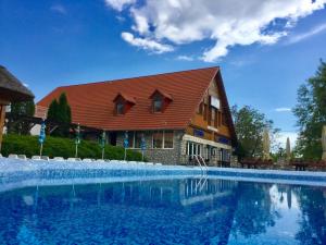 a large swimming pool in front of a house at Wellness Park Pension in Gyenesdiás