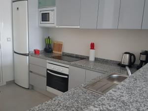 プレヤス・デ・オリフエラにあるLuxury ground floor apartment Terrazzas de Campoamor PG009のキッチン(白い冷蔵庫、シンク付)