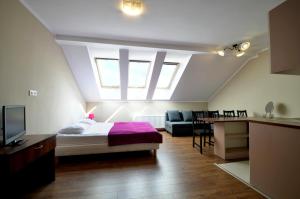 a bedroom with a bed and a living room at Pensjonat Ślepowron in Międzywodzie