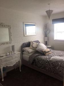 a bedroom with a bed with pillows and a table at Southend Airport Bed & Breakfast in Rochford