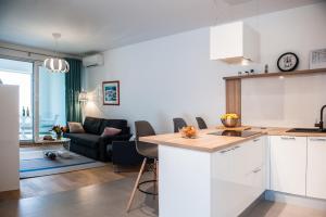 a kitchen and living room with white cabinets and a couch at Apartment Morska vila in Split +22 photos