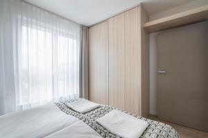 a bedroom with a bed and a large window at Apartament 65 Przy plazy in Władysławowo