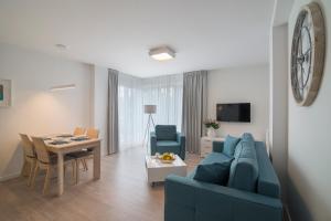 a living room with a blue couch and a table at Apartament 65 Przy plazy in Władysławowo